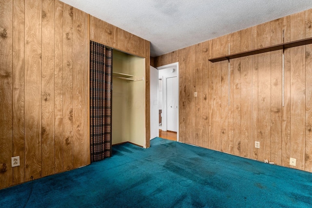 5045 Labelle Dr, Columbus, OH 43232 - unfurnished bedroom featuring wooden walls, carpet flooring, a textured ceiling, and a closet