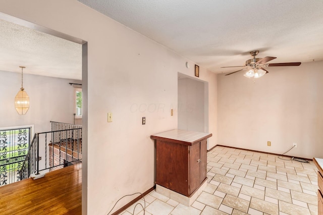 5045 Labelle Dr, Columbus, OH 43232 - spare room featuring ceiling fan, a textured ceiling, baseboards, light tile patterned flooring, and a chandelier