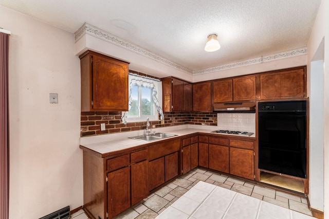 5045 Labelle Dr, Columbus, OH 43232 - kitchen featuring a sink, backsplash, under cabinet range hood, tile counters, and gas cooktop