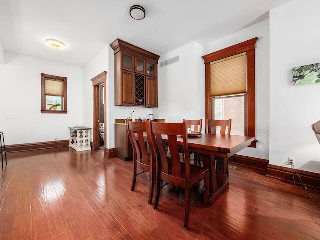 471 W 4th Ave, Columbus, OH 43201 - dining space featuring dark wood-type flooring, baseboards, and bar