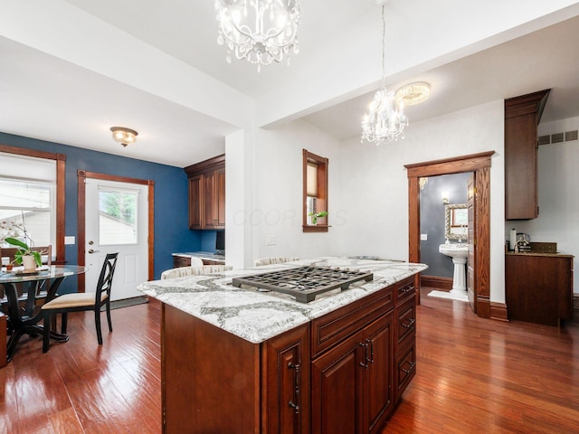 471 W 4th Ave, Columbus, OH 43201 - kitchen with a chandelier, stainless steel gas stovetop, dark wood-style floors, and decorative light fixtures