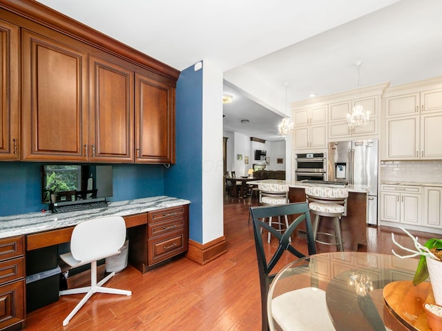 471 W 4th Ave, Columbus, OH 43201 - office with built in study area, light wood finished floors, and a chandelier