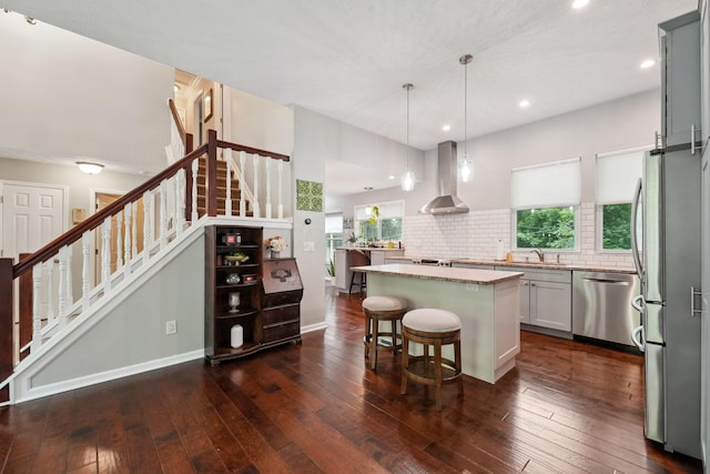5191 Hialeah Ct, Columbus, OH 43221 - kitchen featuring stainless steel appliances, wall chimney exhaust hood, a sink, a kitchen island, and a kitchen bar