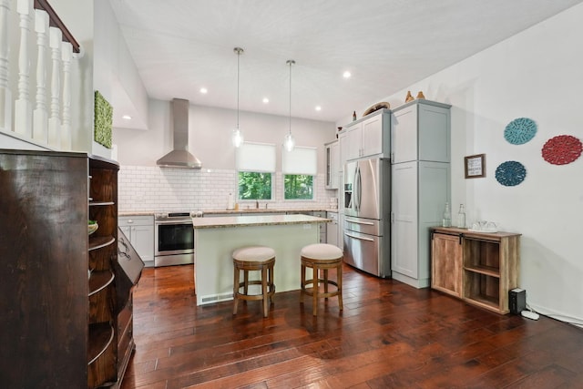 5191 Hialeah Ct, Columbus, OH 43221 - kitchen featuring appliances with stainless steel finishes, wall chimney range hood, backsplash, dark wood-style flooring, and a kitchen island