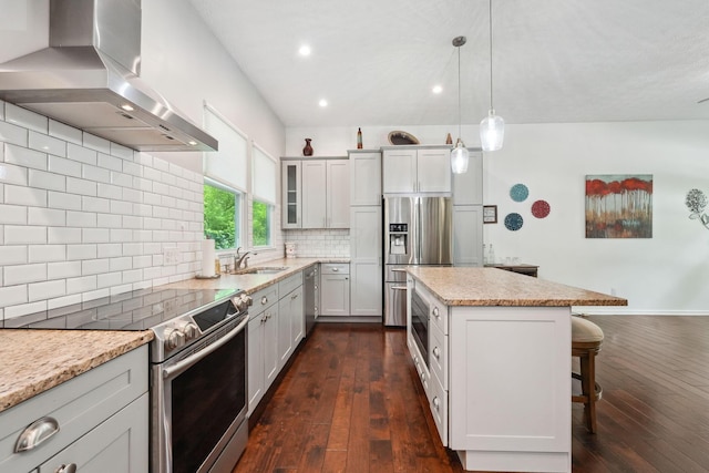 5191 Hialeah Ct, Columbus, OH 43221 - kitchen featuring stainless steel appliances, wall chimney range hood, a kitchen bar, dark wood-style flooring, and recessed lighting