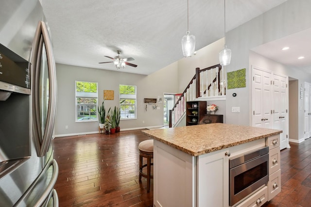 5191 Hialeah Ct, Columbus, OH 43221 - kitchen with stainless steel appliances, dark wood finished floors, open floor plan, baseboards, and hanging light fixtures