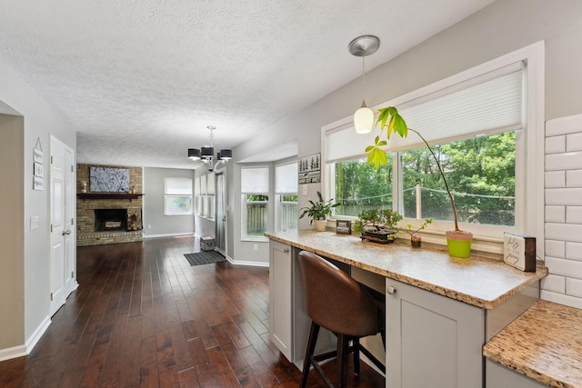 5191 Hialeah Ct, Columbus, OH 43221 - kitchen featuring a textured ceiling, light countertops, open floor plan, baseboards, and decorative light fixtures