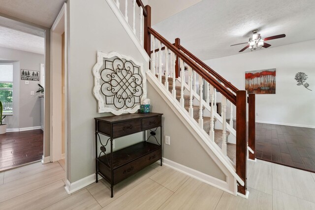 5191 Hialeah Ct, Columbus, OH 43221 - stairway featuring ceiling fan, wood finished floors, a textured ceiling, and baseboards