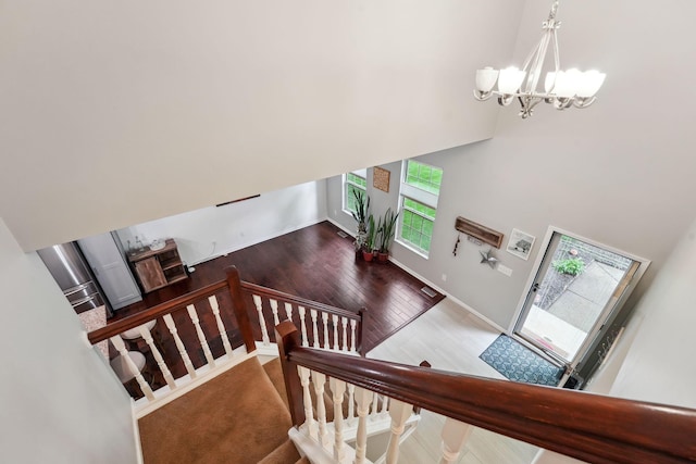 5191 Hialeah Ct, Columbus, OH 43221 - stairs with a chandelier, wood finished floors, a high ceiling, and baseboards