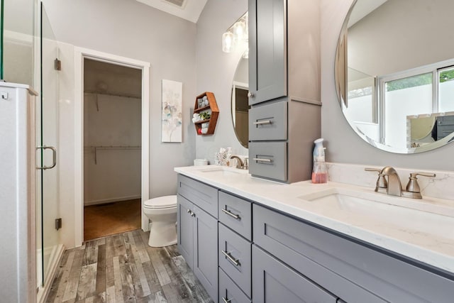 5191 Hialeah Ct, Columbus, OH 43221 - full bathroom with wood finished floors, double vanity, a shower stall, toilet, and a walk in closet