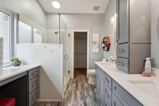 5191 Hialeah Ct, Columbus, OH 43221 - full bath with wood finished floors, a stall shower, double vanity, toilet, and a walk in closet