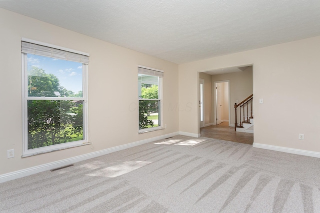 8732 Eastfield Ct, Pickerington, OH 43147 - empty room with light colored carpet, stairs, and a textured ceiling
