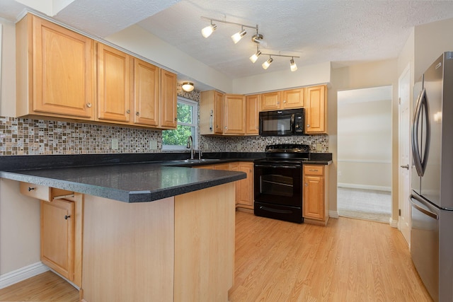 8732 Eastfield Ct, Pickerington, OH 43147 - kitchen featuring black appliances, a peninsula, dark countertops, light wood-style flooring, and a textured ceiling