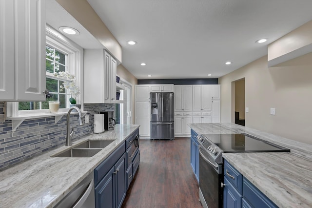 68 Nadine Pl N, Westerville, OH 43081 - kitchen featuring appliances with stainless steel finishes, blue cabinetry, white cabinetry, light stone countertops, and recessed lighting