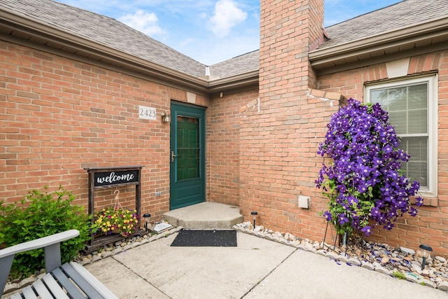 2423 Hooverside Ln, Grove City, OH 43123 - property entrance with a chimney, brick siding, and roof with shingles