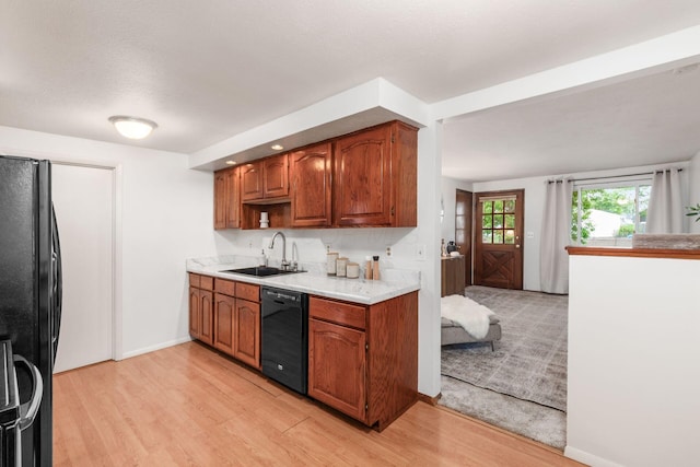 815 Savannah Dr, Columbus, OH 43228 - kitchen featuring black appliances, light countertops, light wood-style floors, and brown cabinetry