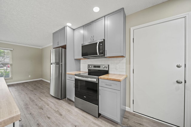 4150 Demorest Rd, Grove City, OH 43123 - kitchen featuring appliances with stainless steel finishes, gray cabinets, butcher block countertops, a textured ceiling, and light wood finished floors