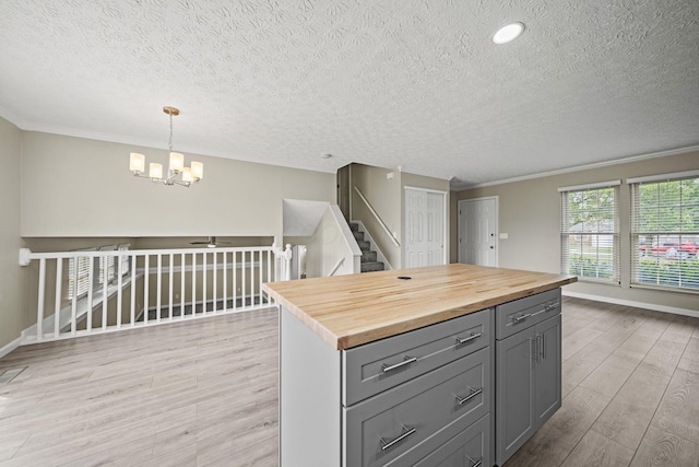 4150 Demorest Rd, Grove City, OH 43123 - kitchen with gray cabinetry, a textured ceiling, light wood-type flooring, butcher block countertops, and a chandelier