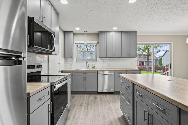 4150 Demorest Rd, Grove City, OH 43123 - kitchen with stainless steel appliances, gray cabinetry, butcher block counters, a sink, and a textured ceiling