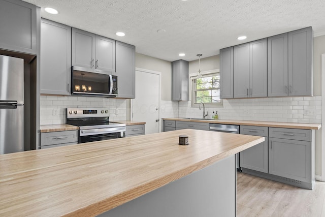 4150 Demorest Rd, Grove City, OH 43123 - kitchen featuring wood counters, appliances with stainless steel finishes, gray cabinetry, a sink, and light wood-type flooring