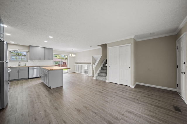 4150 Demorest Rd, Grove City, OH 43123 - kitchen with stainless steel dishwasher, gray cabinetry, a textured ceiling, open floor plan, and a center island