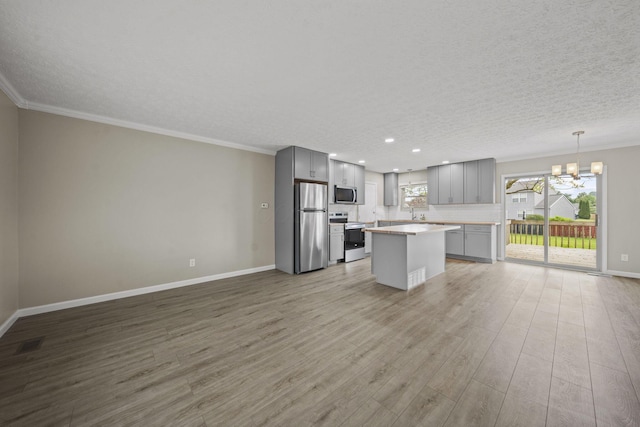 4150 Demorest Rd, Grove City, OH 43123 - kitchen with appliances with stainless steel finishes, gray cabinets, a chandelier, wood finished floors, and light countertops