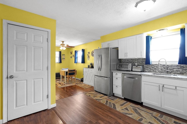 13111 King Rd NE, Thornville, OH 43076 - kitchen with stainless steel appliances, a sink, white cabinetry, tasteful backsplash, and a textured ceiling