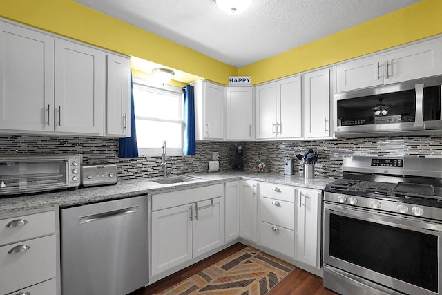 13111 King Rd NE, Thornville, OH 43076 - kitchen with stainless steel appliances, a sink, decorative backsplash, white cabinetry, and a textured ceiling