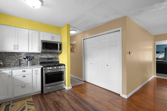 13111 King Rd NE, Thornville, OH 43076 - kitchen with stainless steel appliances, dark wood-type flooring, baseboards, tasteful backsplash, and white cabinetry