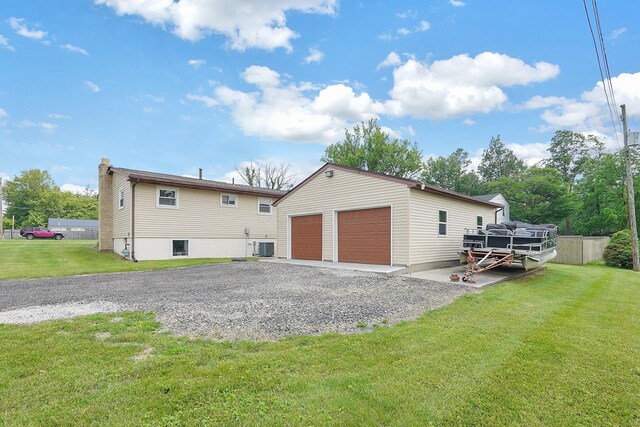 13111 King Rd NE, Thornville, OH 43076 - rear view of property with an outdoor structure, a detached garage, a lawn, cooling unit, and a chimney