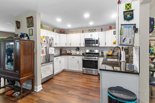 565 S Kellner Rd, Columbus, OH 43209 - kitchen featuring appliances with stainless steel finishes, backsplash, dark wood-style floors, white cabinetry, and a sink