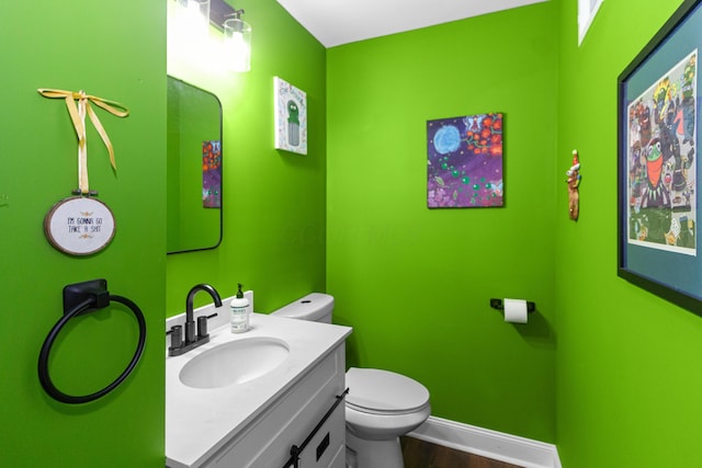565 S Kellner Rd, Columbus, OH 43209 - half bath featuring toilet, vanity, wood finished floors, and baseboards