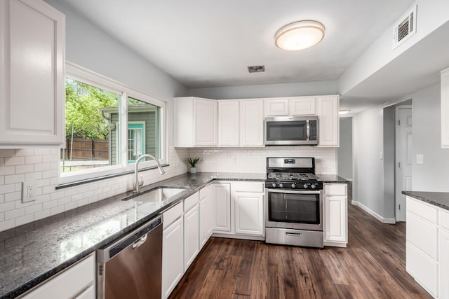 5186 Meadowbrook Dr, Columbus, OH 43207 - kitchen featuring appliances with stainless steel finishes, a sink, dark wood-type flooring, tasteful backsplash, and dark stone countertops