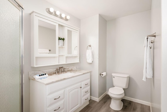 5186 Meadowbrook Dr, Columbus, OH 43207 - bathroom with wood finished floors, vanity, toilet, and baseboards