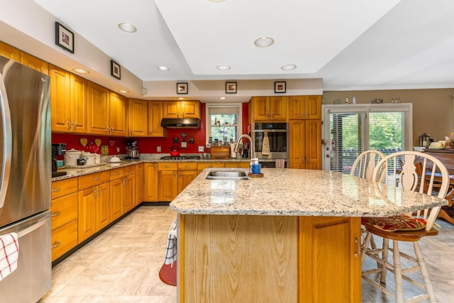 445 Cedar Hill Rd SW, Amanda, OH 43102 - kitchen with appliances with stainless steel finishes, under cabinet range hood, light stone countertops, a center island with sink, and ornamental molding