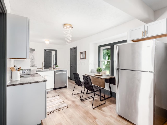 1432 Cordell Ave, Columbus, OH 43211 - kitchen featuring stainless steel appliances, light wood-style flooring, white cabinetry, and dark stone countertops
