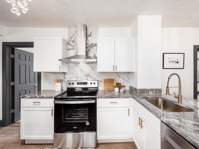 1432 Cordell Ave, Columbus, OH 43211 - kitchen featuring stainless steel appliances, wall chimney exhaust hood, stone counters, tasteful backsplash, and white cabinets