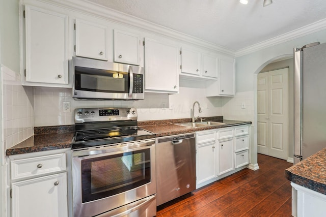 3840 Farm Brook Ln, Columbus, OH 43204 - kitchen with stainless steel appliances, white cabinets, dark wood finished floors, crown molding, and decorative backsplash