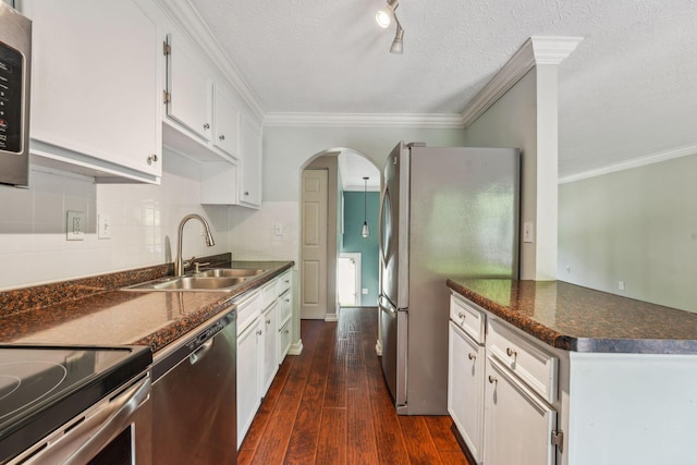 3840 Farm Brook Ln, Columbus, OH 43204 - kitchen with appliances with stainless steel finishes, dark countertops, arched walkways, ornamental molding, and dark wood-type flooring