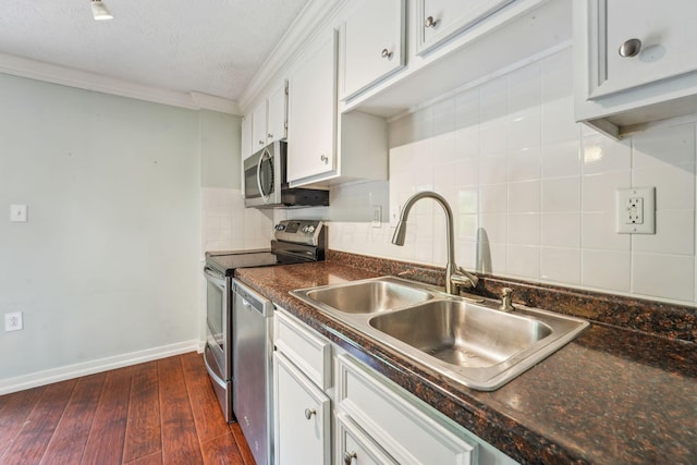 3840 Farm Brook Ln, Columbus, OH 43204 - kitchen with stainless steel appliances, dark countertops, white cabinets, tasteful backsplash, and crown molding