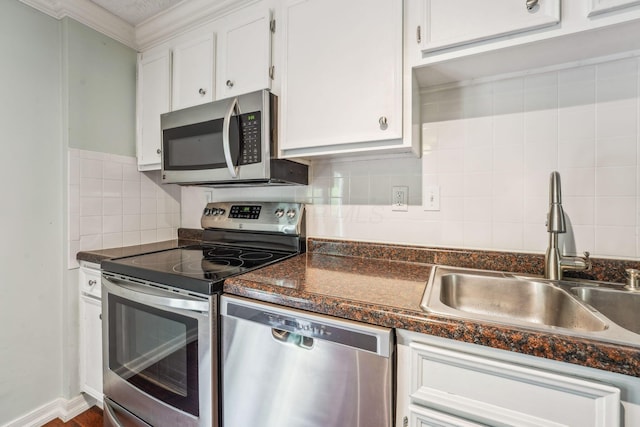 3840 Farm Brook Ln, Columbus, OH 43204 - kitchen with stainless steel appliances, dark countertops, white cabinetry, backsplash, and ornamental molding