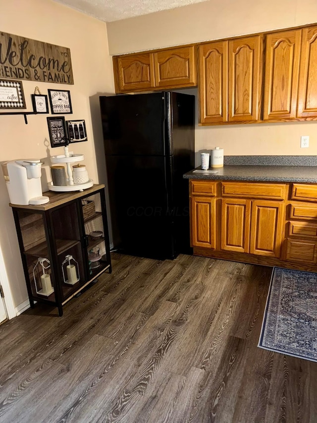 375 Darby Ct, Galloway, OH 43119 - kitchen with freestanding refrigerator, dark wood finished floors, brown cabinets, and dark countertops
