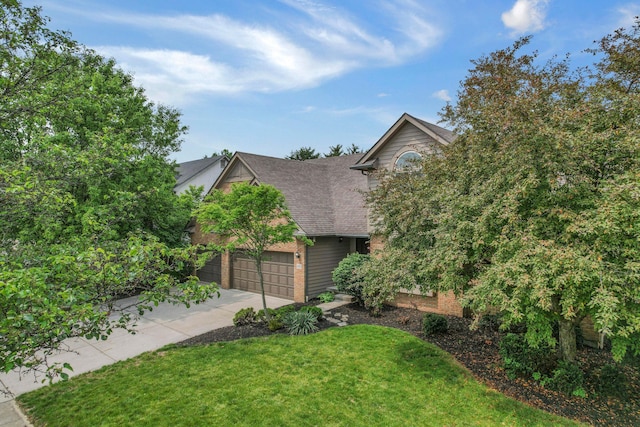 4583 Hunting Creek Dr, Grove City, OH 43123 - obstructed view of property featuring concrete driveway, a front lawn, a garage, and brick siding