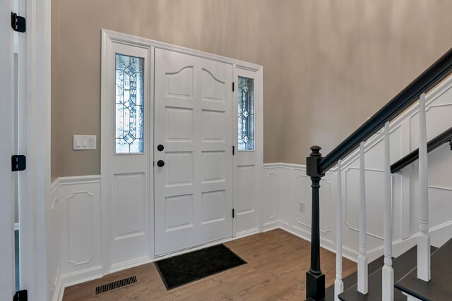 4583 Hunting Creek Dr, Grove City, OH 43123 - entryway with a decorative wall, dark wood-style floors, wainscoting, and stairway