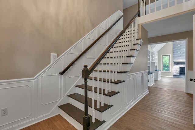 4583 Hunting Creek Dr, Grove City, OH 43123 - stairway featuring wood finished floors, a decorative wall, and wainscoting