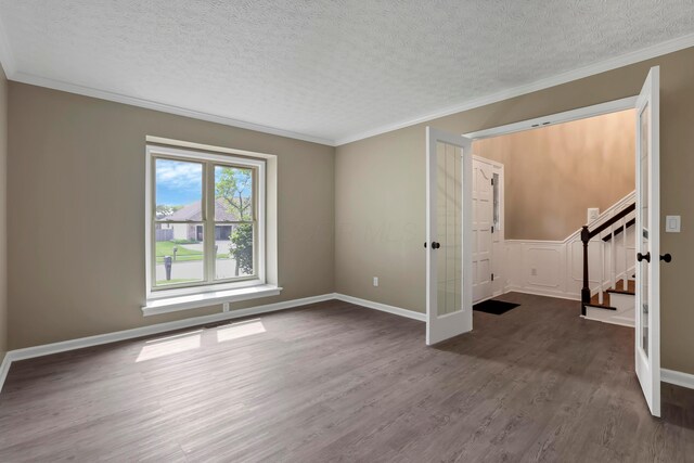 4583 Hunting Creek Dr, Grove City, OH 43123 - empty room featuring a textured ceiling, wood finished floors, french doors, stairway, and crown molding