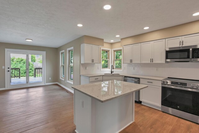 4583 Hunting Creek Dr, Grove City, OH 43123 - kitchen featuring appliances with stainless steel finishes, a sink, light wood-type flooring, tasteful backsplash, and recessed lighting