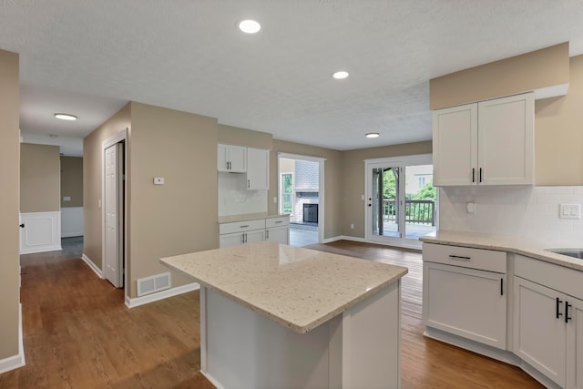 4583 Hunting Creek Dr, Grove City, OH 43123 - kitchen featuring tasteful backsplash, light stone countertops, wood finished floors, recessed lighting, and a textured ceiling