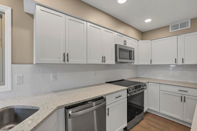 4583 Hunting Creek Dr, Grove City, OH 43123 - kitchen with stainless steel appliances, white cabinets, recessed lighting, tasteful backsplash, and light stone countertops