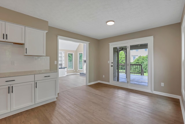 4583 Hunting Creek Dr, Grove City, OH 43123 - unfurnished dining area featuring light wood-style flooring, baseboards, and a textured ceiling